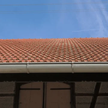 A photo of a roof with clean gutters in Cincinnati, OH. Our gutter cleaning service ensures your system is free of debris, allowing for proper drainage and preventing water damage.